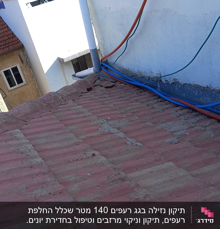 גג רעפים אדום עם צינורות כחולים וכתומים